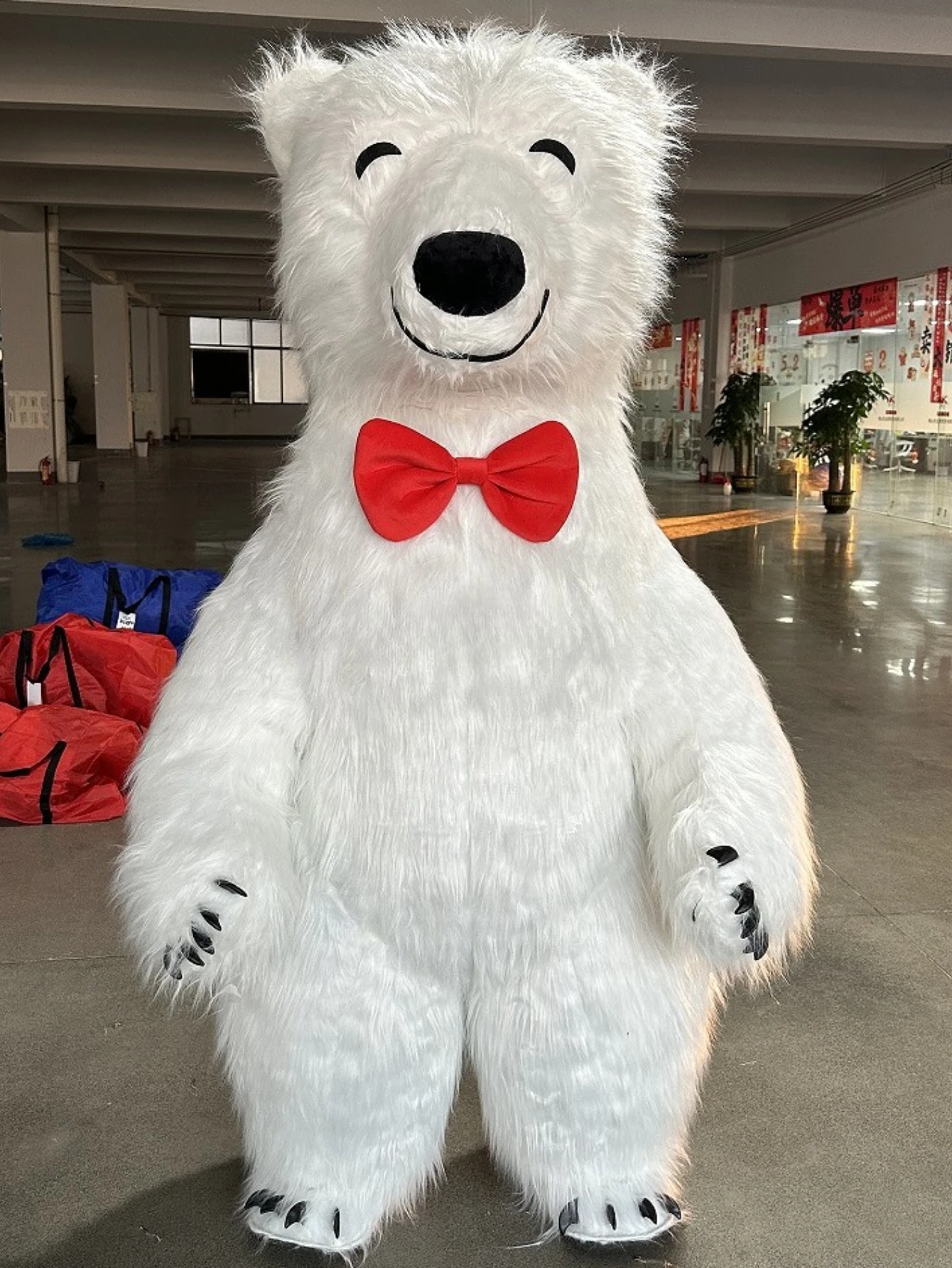 巨大な白いホッキョクグマの着ぐるみ。笑顔の表情で、毛皮のよう - Suits のレビューと価格